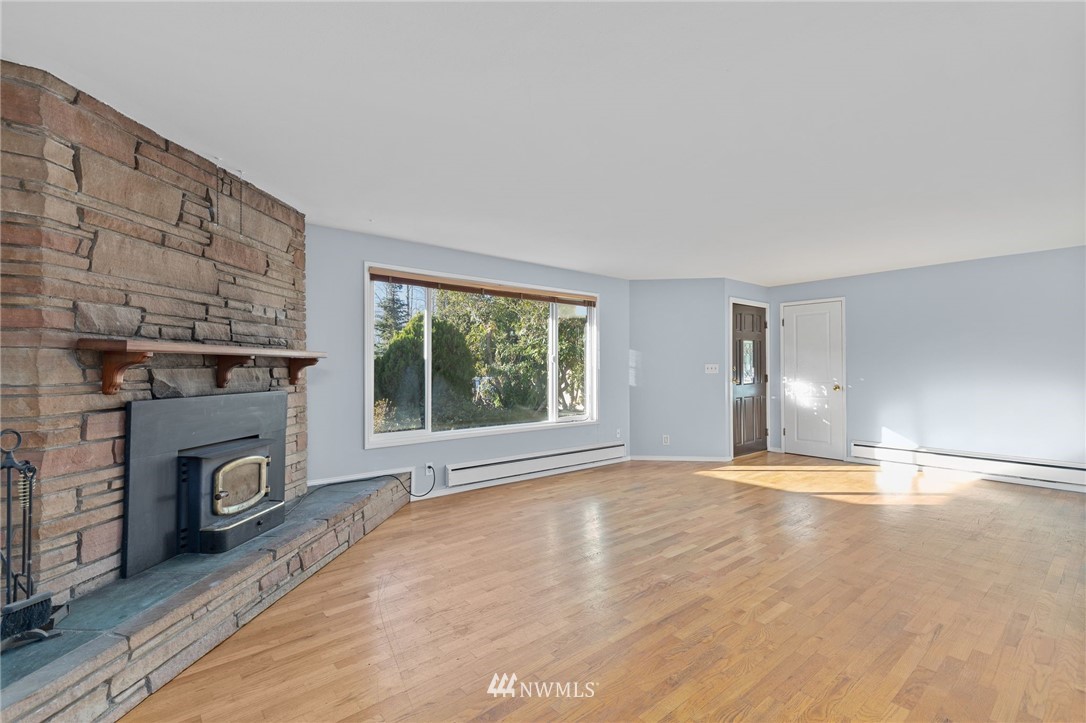645 240th Street Southeast Bothell, WA 98021 - Photo 4 of 25 a view of empty room with a fireplace and wooden floor