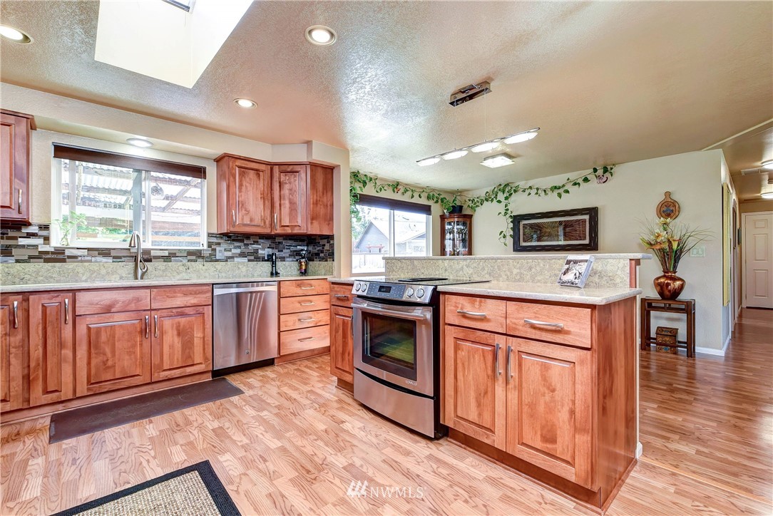 14221 Seattle Hill Road Snohomish, WA 98296 - Photo 9 of 38 a kitchen with stainless steel appliances granite countertop a stove cabinets and wooden floor