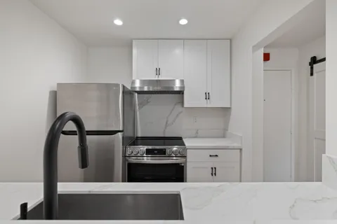 a kitchen with stainless steel appliances granite countertop a refrigerator and a stove
