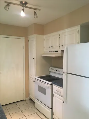 a kitchen with white cabinets and white appliances