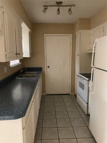 a kitchen that has a sink a stove and a refrigerator