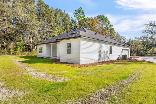 a view of a house with pool and a yard