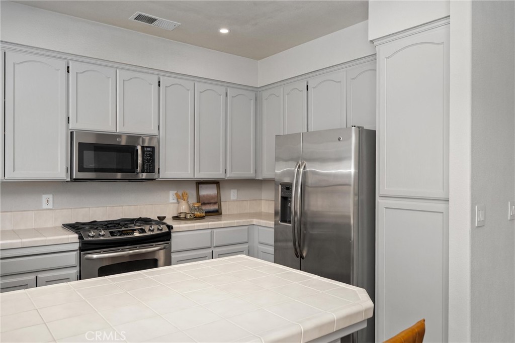 1921 Ascolano Way Chico, CA 95928 - Photo 18 of 42 a kitchen with stainless steel appliances a refrigerator a stove a microwave and cabinets