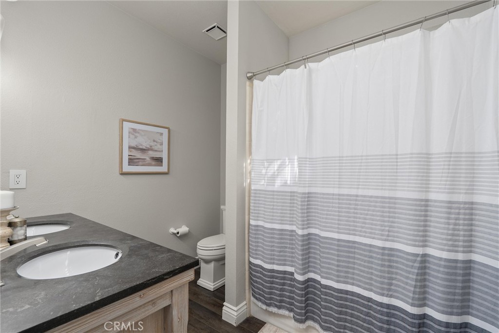 1921 Ascolano Way Chico, CA 95928 - Photo 27 of 42 a bathroom with a granite countertop sink a toilet and a mirror