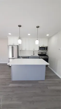 a kitchen with kitchen island a counter top space a stove and cabinets