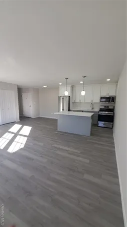 a view of kitchen and kitchen with granite countertop wooden floor
