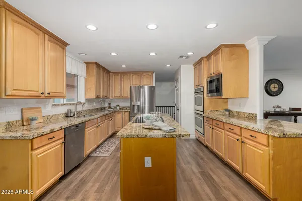 a kitchen with stove a sink dishwasher and refrigerator with wooden floor