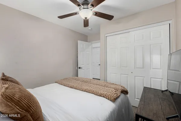 a bedroom with a bed and a ceiling fan