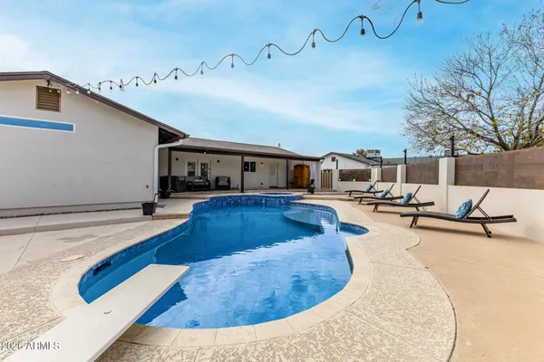 a view of a house with swimming pool and sitting area