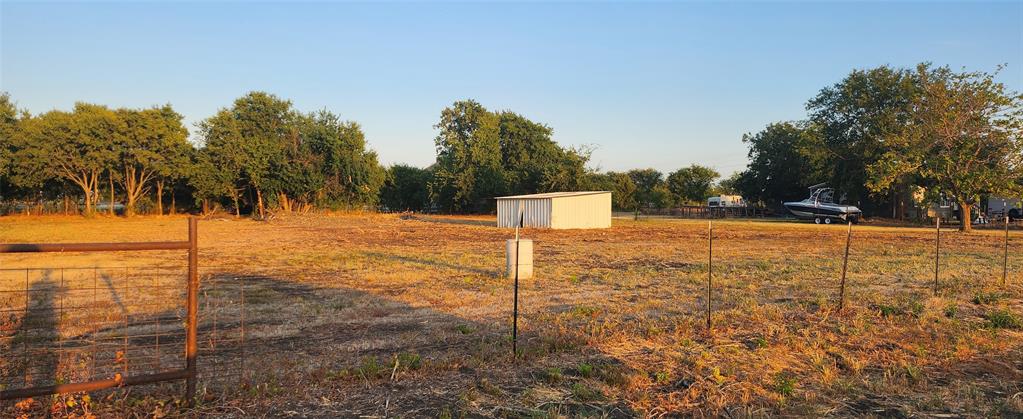 592 Pike Road Gunter, TX 75058 - Photo 14 of 40 View of yard featuring a rural view, an outbuilding, and fence