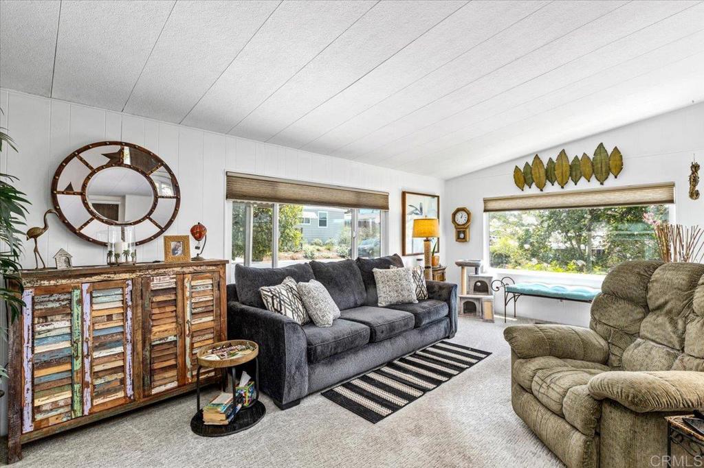 18218 Paradise Mountain Road, Unit 116 Valley Center, CA 92082 - Photo 1 of 35 a living room with furniture a fireplace and a large window