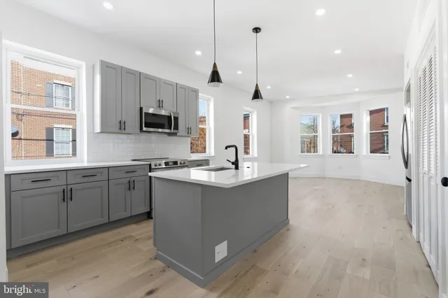 a large kitchen with kitchen island a sink stainless steel appliances and cabinets