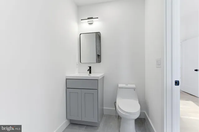 a bathroom with a toilet sink and mirror