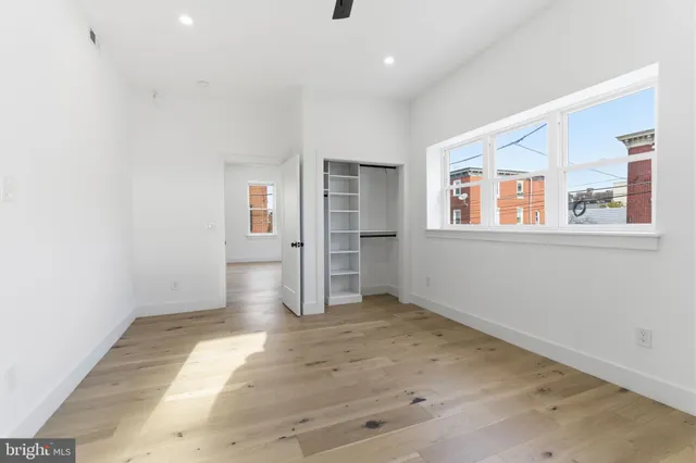an empty room with windows and closet