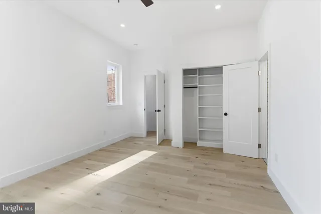 an empty room with closet and wooden floor