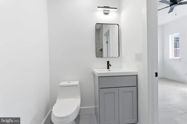 a bathroom with a toilet a sink and mirror