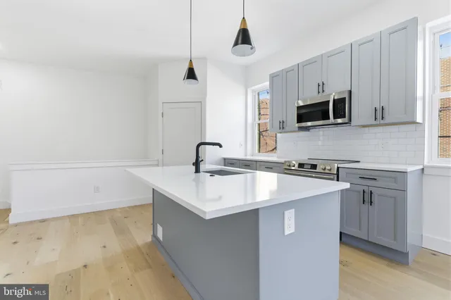 a kitchen with stainless steel appliances a sink stove and microwave