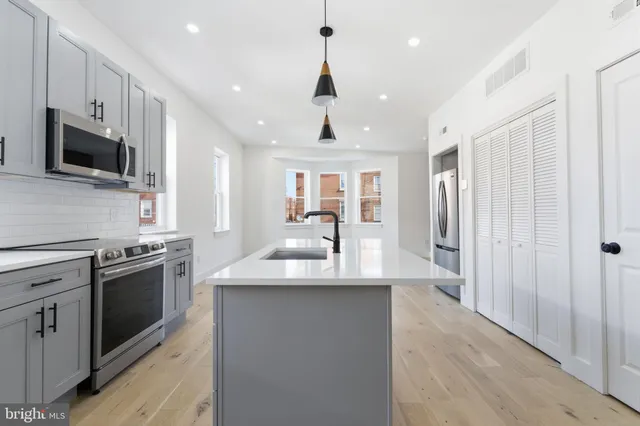 a kitchen with stainless steel appliances granite countertop a sink a stove and a refrigerator