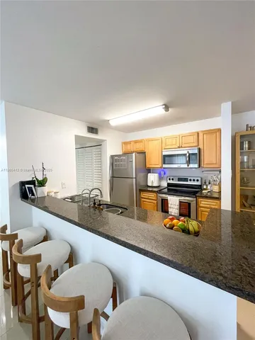 a kitchen with a sink and chairs