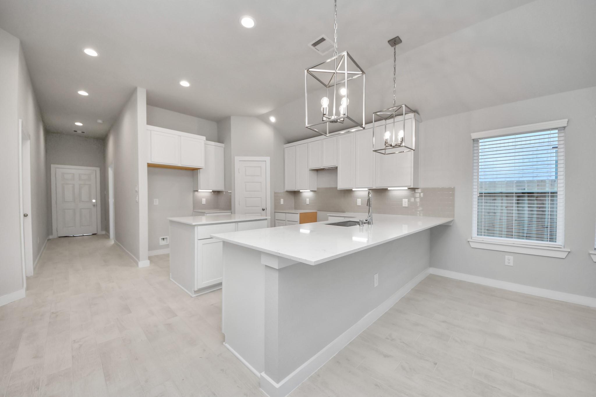 15707 Telge Ridge Lane Cypress, TX 77429 - Photo 19 of 38 a large kitchen with kitchen island a sink a center island stainless steel appliances and a window