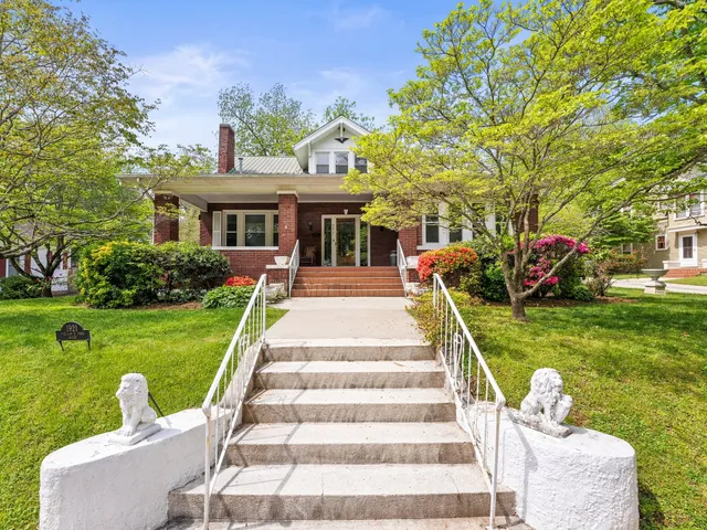 a front view of a house with fountain and garden