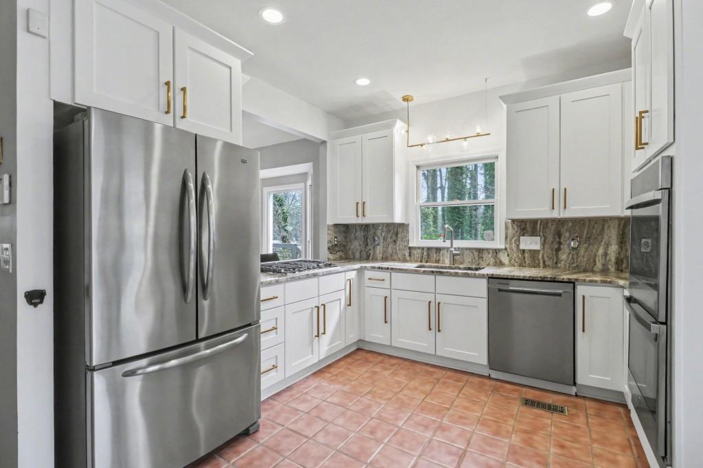 3793 Market Crescent Clarkston, GA 30021 - Photo 3 of 35 a kitchen with granite countertop stainless steel appliances a refrigerator sink and microwave
