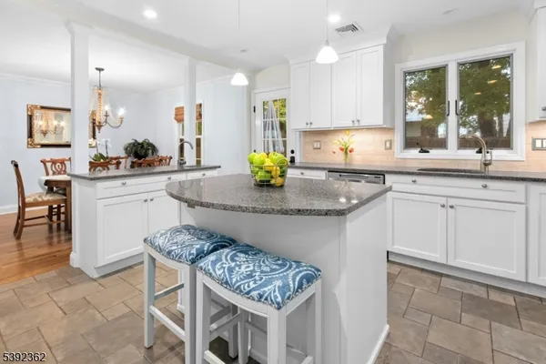 a kitchen with stainless steel appliances granite countertop a sink and a white cabinets