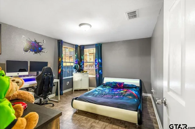 a bedroom with furniture and a flat screen tv