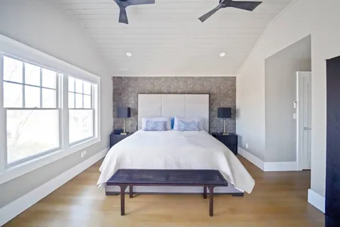 a bedroom with a bed a large window and furniture