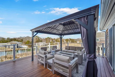 a backyard of a house with wooden floor a barbeque oven and outdoor seating