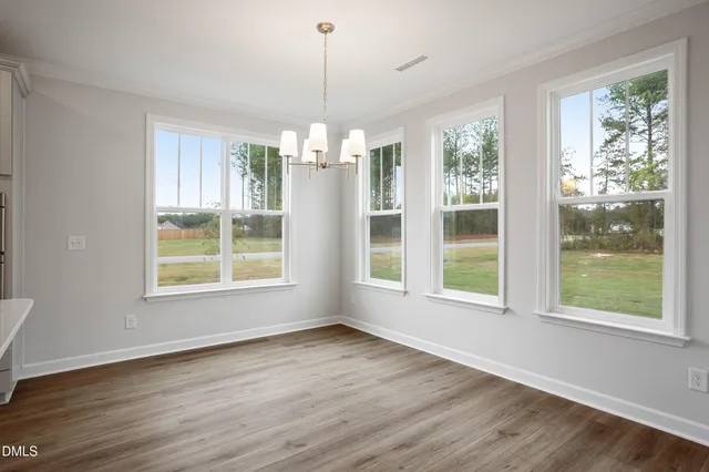 a view of empty room with wooden floor and fireplace