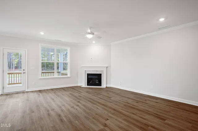 en empty room with windows and chandelier fan