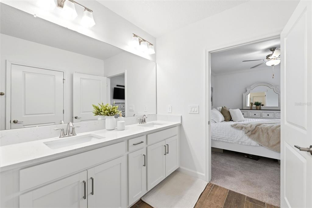 10799 Gable Dig Loop San Antonio, FL 33576 - Photo 12 of 19 a en suite bathroom with a double vanity sink and mirror