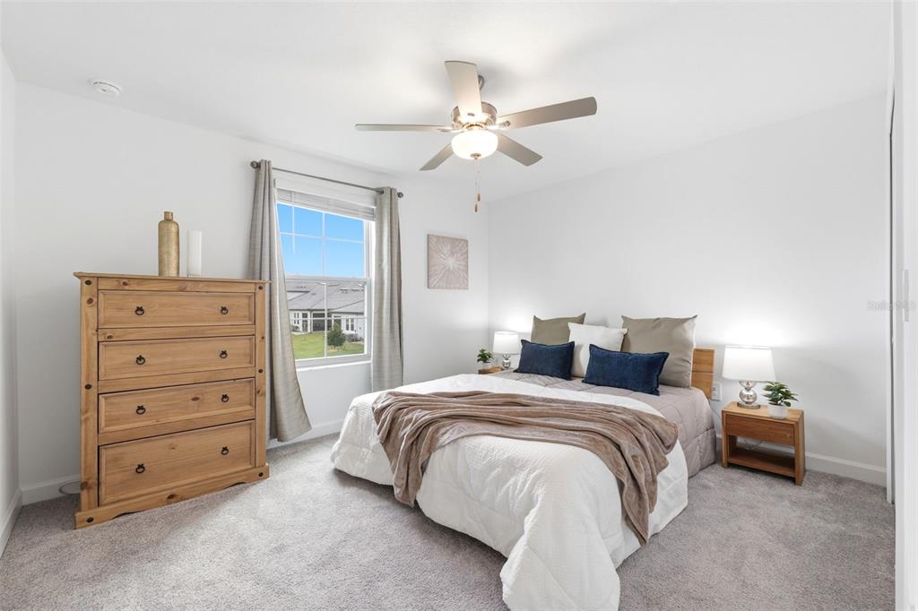 10799 Gable Dig Loop San Antonio, FL 33576 - Photo 15 of 19 a bedroom with a bed and a chandelier