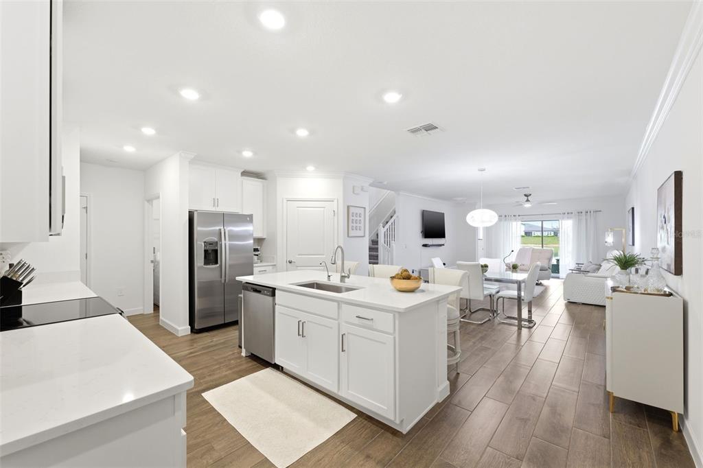 10799 Gable Dig Loop San Antonio, FL 33576 - Photo 3 of 19 a kitchen with a sink a refrigerator and white cabinets