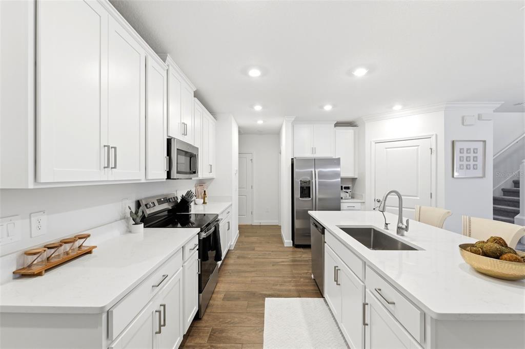 10799 Gable Dig Loop San Antonio, FL 33576 - Photo 4 of 19 a kitchen with a sink a stove and cabinets