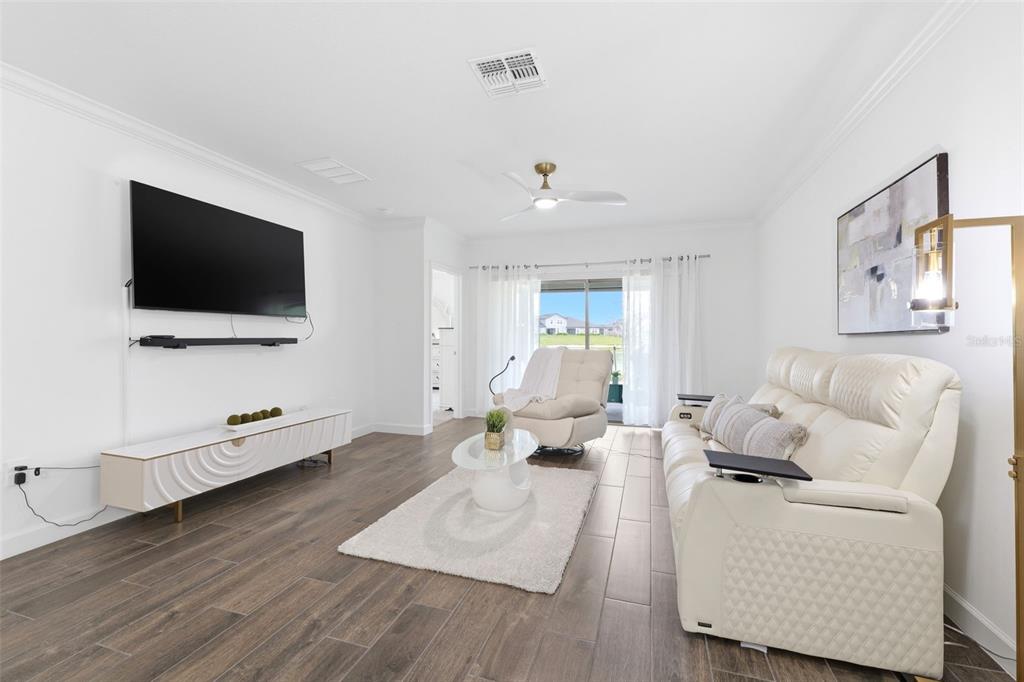 10799 Gable Dig Loop San Antonio, FL 33576 - Photo 9 of 19 a living room with furniture and a flat screen tv