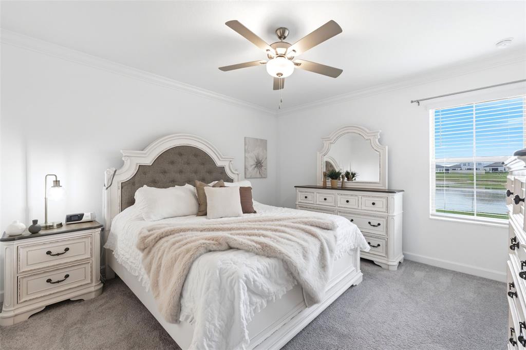 10799 Gable Dig Loop San Antonio, FL 33576 - Photo 10 of 19 a bedroom with a bed and a chandelier