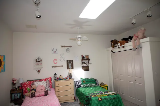a bedroom with furniture and a chandelier fan