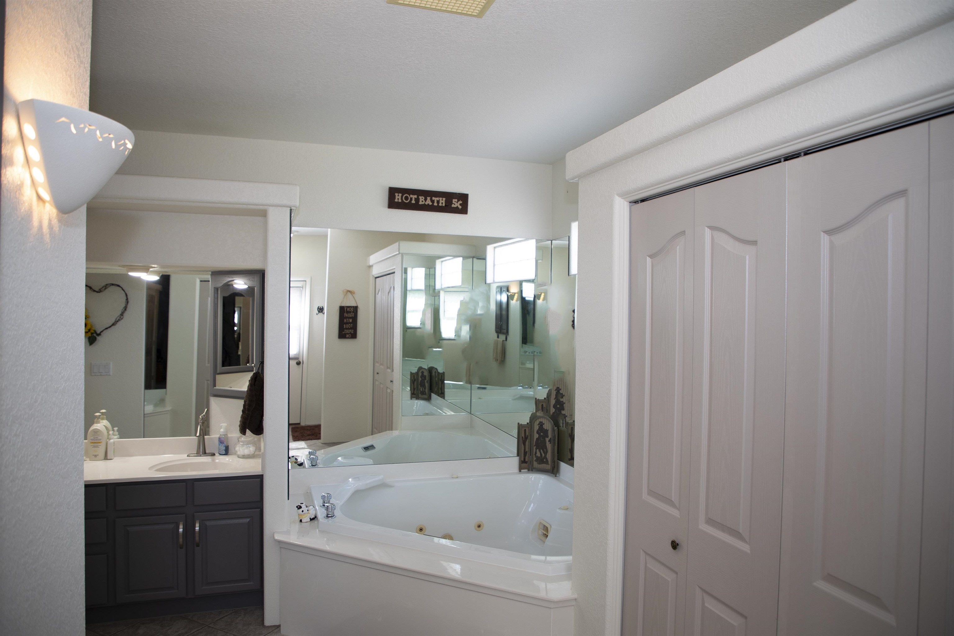 57178 Oe Road Collbran, CO 81624 - Photo 38 of 41 a bathroom with a bathtub a sink and a large mirror