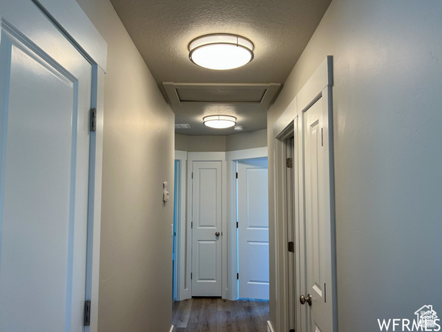 702 North 100 West Logan, UT 84321 - Photo 41 of 58 Corridor with attic access, visible vents, dark wood-type flooring, and a textured ceiling