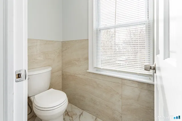 a white toilet sitting in front of a bathroom