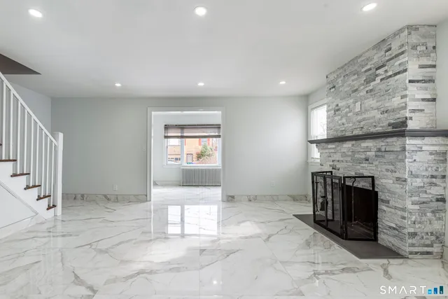 an empty room with a fireplace and entryway