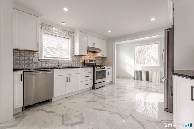 a kitchen with granite countertop a stove sink and cabinets