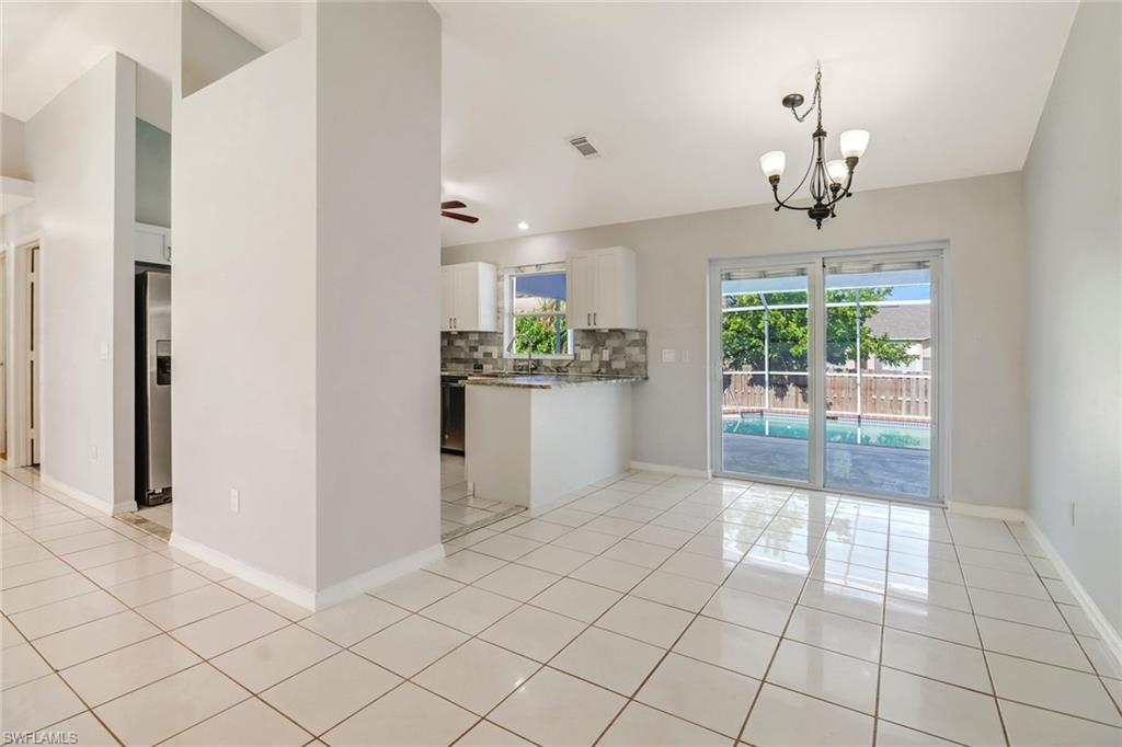 18250 Maple Road Fort Myers, FL 33967 - Photo 7 of 26 a kitchen with stainless steel appliances a refrigerator and a stove top oven