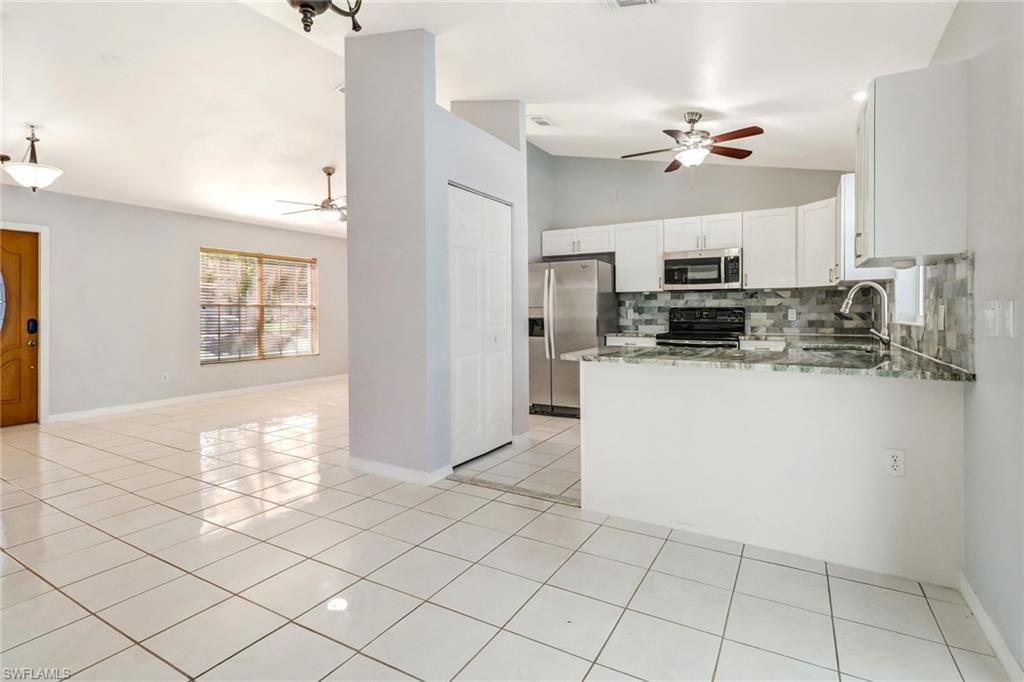 18250 Maple Road Fort Myers, FL 33967 - Photo 8 of 26 a kitchen with kitchen island granite countertop appliances cabinets and a sink