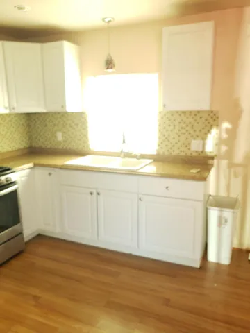 a view of a room with wooden floor washer and dryer