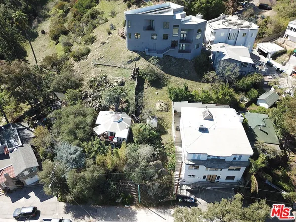 an aerial view of a house with a yard and trees