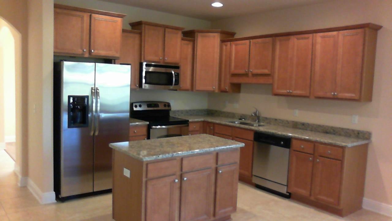 41 Twain Trail Freeport, FL 32439 - Photo 3 of 19 a kitchen with a sink a microwave a refrigerator and cabinets