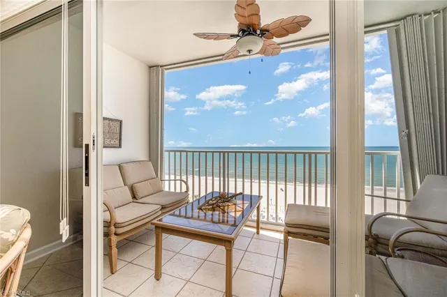 a living room with furniture and a floor to ceiling window